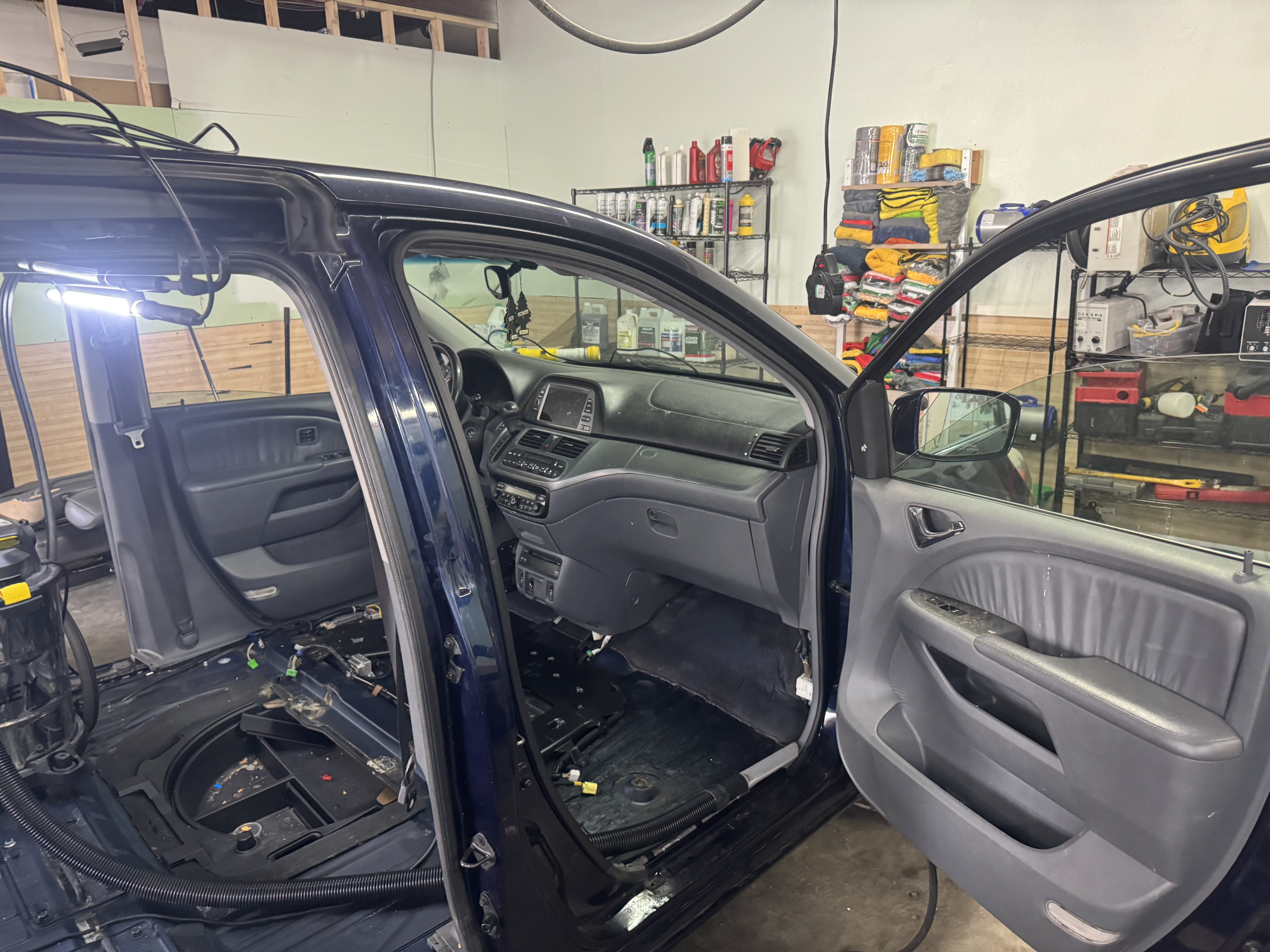 A minivan interior stripped down to the floor for shampoo and detailing